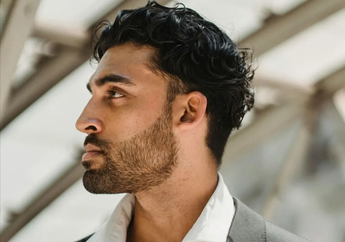 Portrait de profil d'un homme barbu avec un arrière-plan architectural moderne