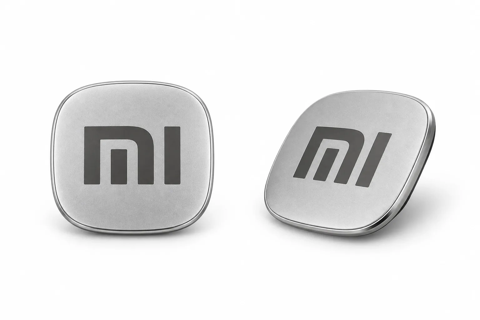 Zwei silberne Abzeichen mit dem Mi-Logo.