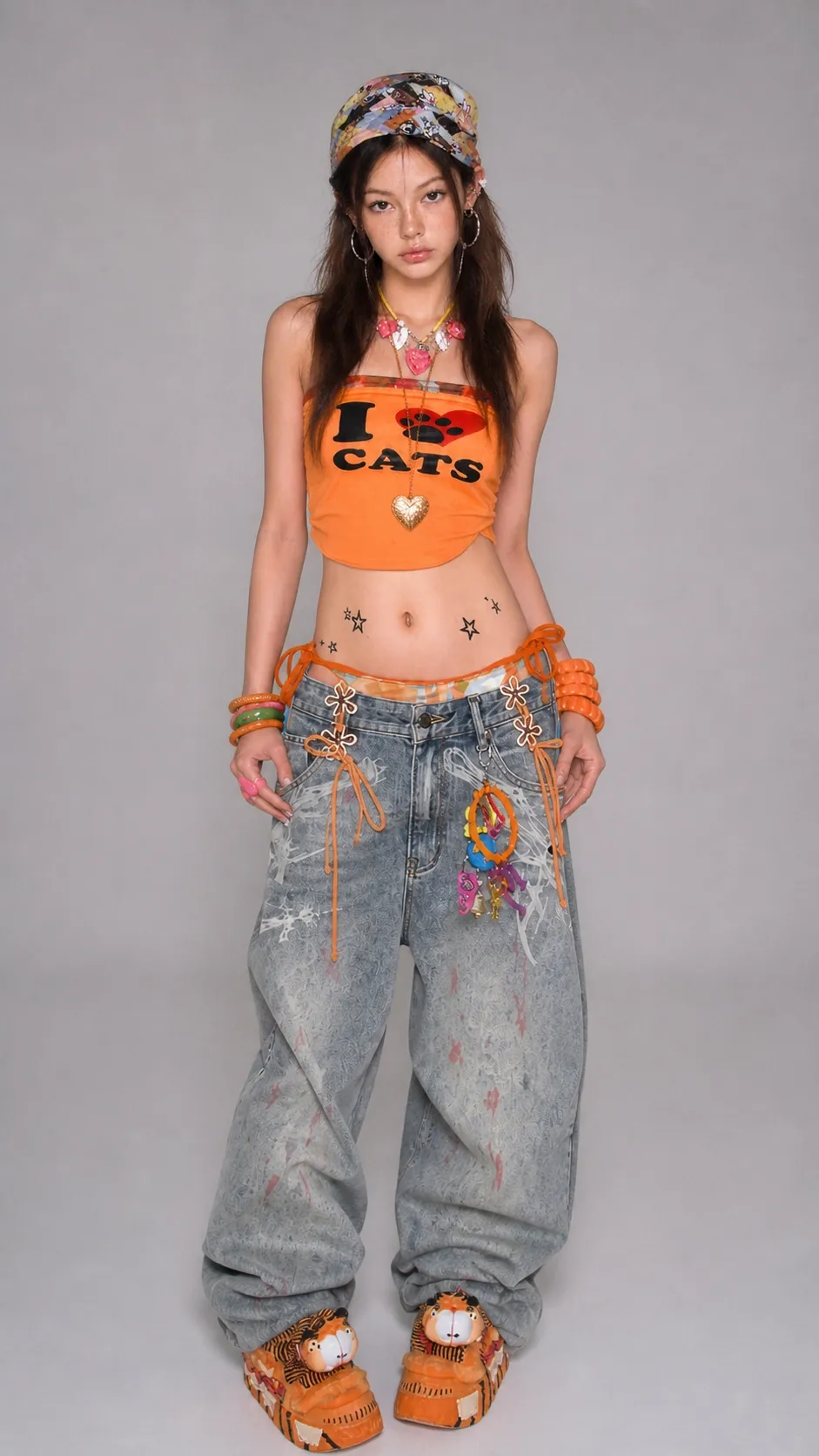 A model poses in a colorful outfit with a crop top and baggy jeans, showcasing accessories.