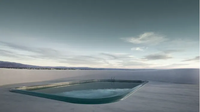 A sleek, modern pool overlooking a serene landscape under a cloudy sky.
